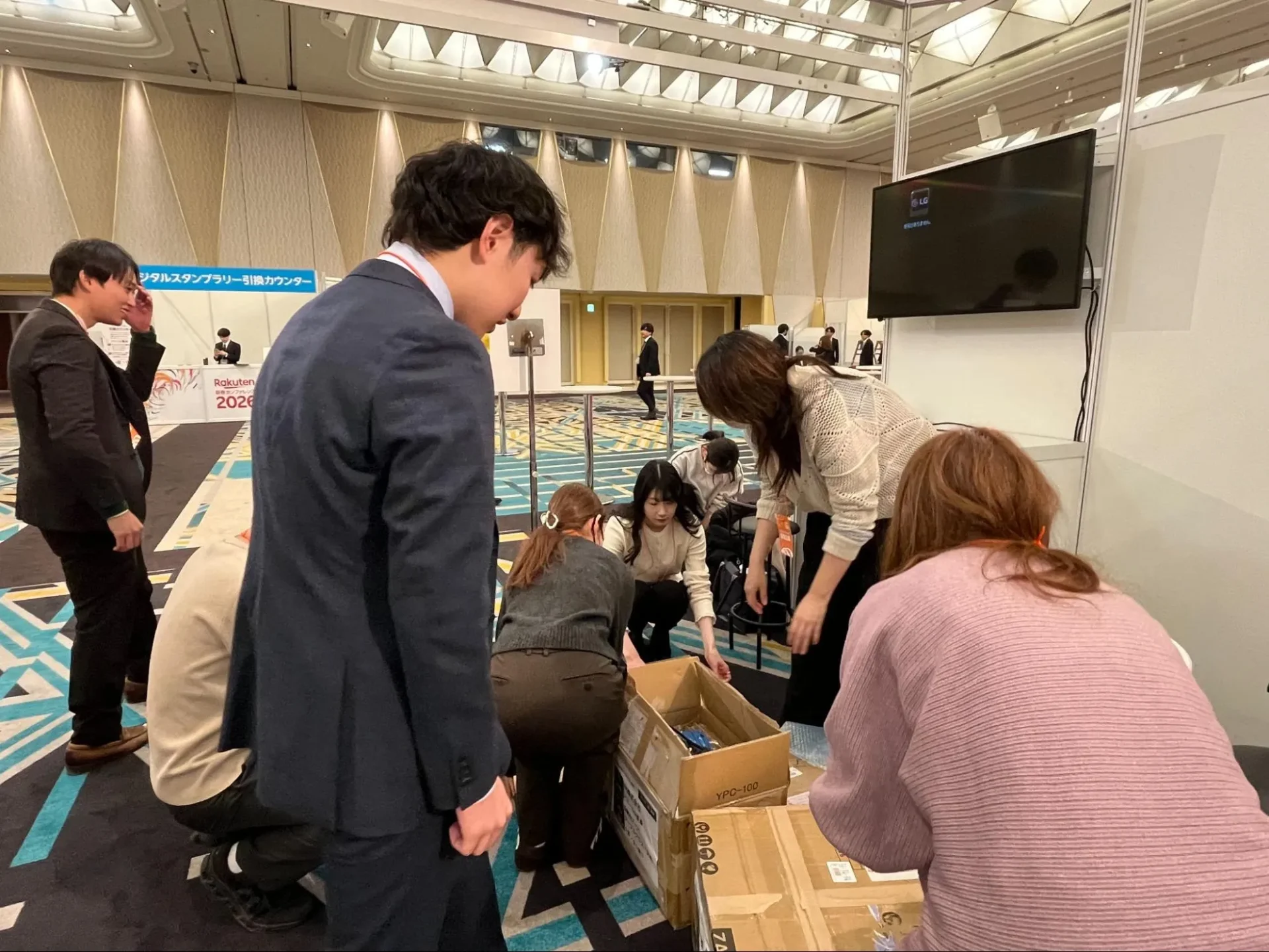 イベント終了後、スタッフ全員で段ボールから備品をしまい、チーム一丸となって片づけをしている様子